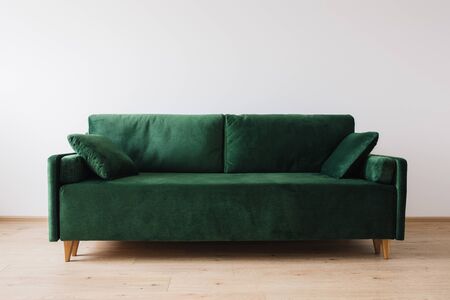 modern green sofa with pillows in roomの写真素材