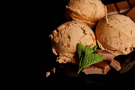 fresh delicious chocolate ice cream with mint leaves isolated on black
