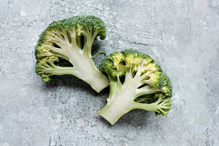 top view of fresh green cut broccoli on grey surfaceの写真素材