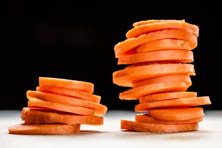 close up view of fresh ripe carrot slices isolated on blackの写真素材