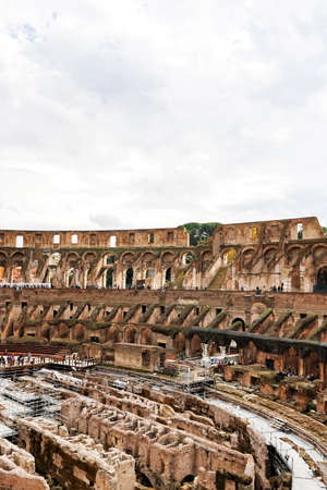 ROME, ITALY - APRIL 10, 2020: ruins of historical colosseum against cloudy sky