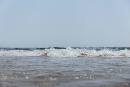 Selective focus of sea with waves and blue sky at background in Catalonia, Spainの写真素材