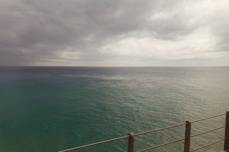 Selective focus of bridge with seascape and overcast clouds in Catalonia, Spain