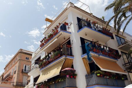 Low angle view of flowers on balcony of house with cloudy sky at background, Catalonia, Spain