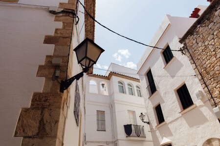 Low angle view of lantern on angle of building facade with blue sky at background, Catalonia, Spainの写真素材