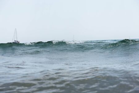 Surface level of yachts in sea with waves and blue sky at background, Catalonia, Spain