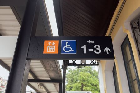 Signs and symbols on nameplate of train station in Catalonia, Spain