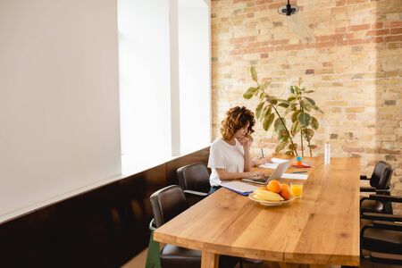 freelancer mother working from home while cute daughter drawing on paperの写真素材