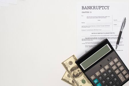 top view of bankruptcy paper with pen, money and calculator on white backgroundの写真素材