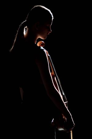 silhouette of female musician holding violin isolated on blackの写真素材