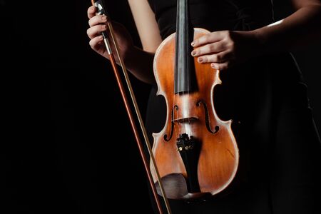 partial view of musician holding violin isolated on black