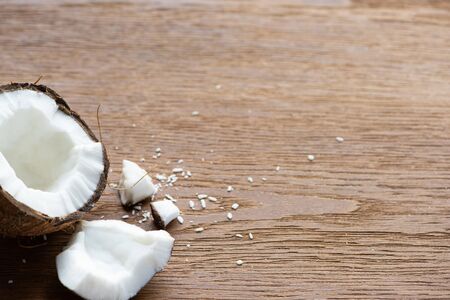 fresh tasty coconut half near flakes on wooden tableの写真素材