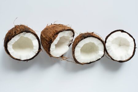 top view of fresh tasty coconut halves on white backgroundの写真素材
