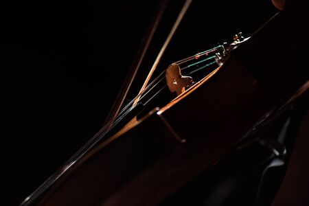 partial view of musician playing symphony on violin isolated on blackの写真素材