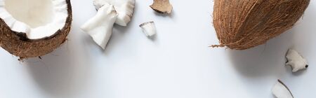 top view of whole and cracked tasty coconut half and pieces on white background, panoramic shotの写真素材