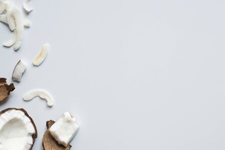 top view of fresh tasty cracked coconut half and pieces on white background
