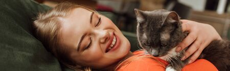 panoramic concept of cheerful woman looking at cute cat