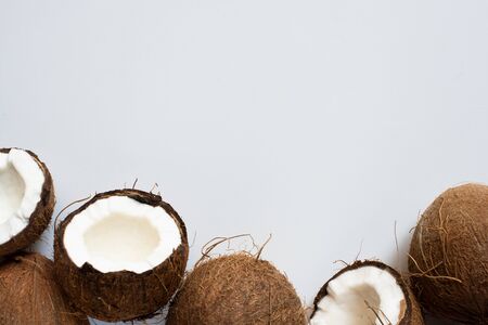 top view of fresh tasty whole coconuts and halves on white backgroundの写真素材