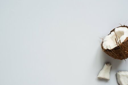 top view of fresh tasty coconut half and cracked pieces on white background