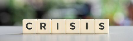 horizontal image of white cubes with word crisis on white surface