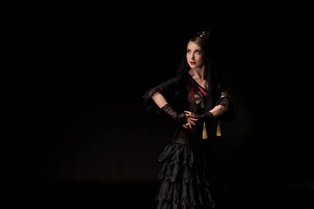pretty young flamenco dancer standing isolated on blackの写真素材
