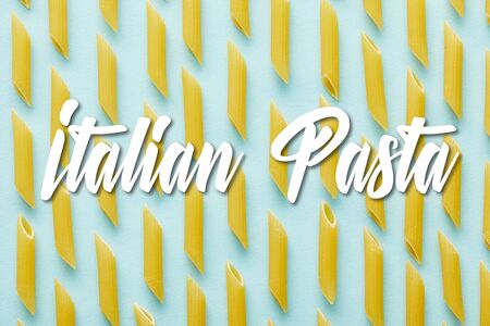 flat lay with raw penne on blue background with Italian pasta illustrationの写真素材