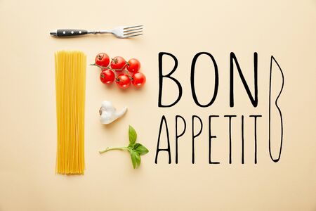 flat lay with delicious spaghetti with tomato sauce ingredients on yellow background with bon appetit illustrationの写真素材
