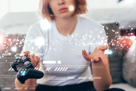 KYIV, UKRAINE - APRIL 15, 2020: cropped view of sad girl playing video game with joystick at home on...