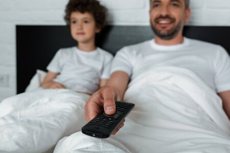 selective focus of cheerful man holding remote controller near sonの写真素材