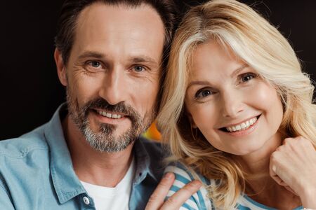 Mature couple smiling at camera at homeの写真素材