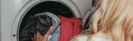 back view of housewife putting laundry into washing machine, horizontal imageの写真素材