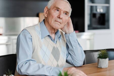 upset pensive elderly man at home during quarantineの写真素材