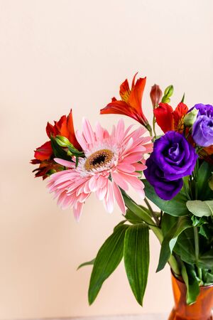 floral composition with bouquet in orange vase isolated on beigeの写真素材
