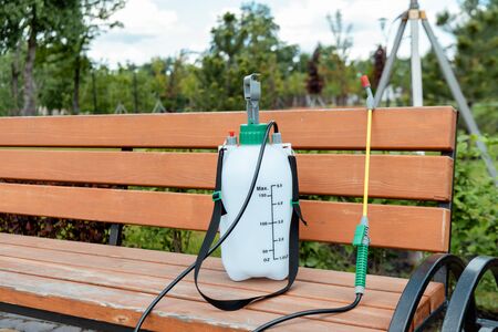 spray bag with disinfectant standing on bench in park during covid-19 pandemicの写真素材