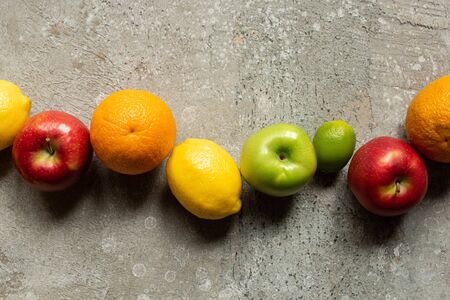 top view of tasty colorful fruits on grey concrete surfaceの写真素材