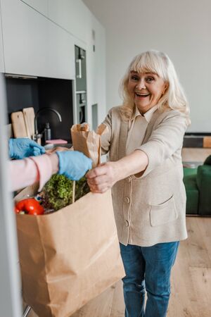 happy elderly woman taking food delivery during coronavirus pandemicの写真素材