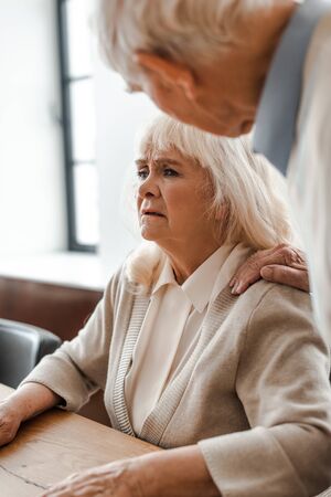 worried elderly couple sitting at home on self isolationの写真素材