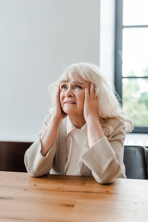 lonely elderly woman having headache at home during self isolationの写真素材