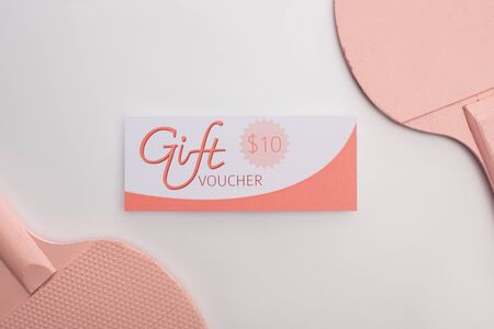 Top view of rackets near gift voucher on white backgroundの写真素材