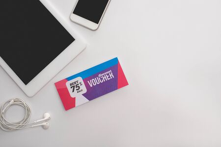 Top view of digital devices near discount voucher with best sale lettering on white backgroundの写真素材
