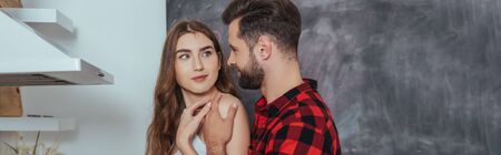 panoramic shot of young man touching shoulder of smiling girlfriendの写真素材