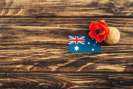top view of australian flag near artificial flower and cookie on wooden surfaceの写真素材