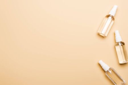 top view of transparent spray bottles with liquid disifectant on beige