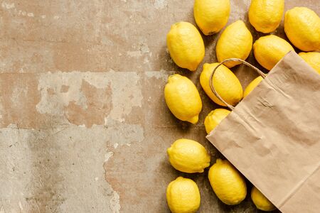 top view of lemons and paper bag on weathered surface