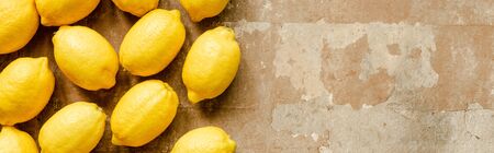 top view of ripe yellow lemons on weathered surface, panoramic shotの写真素材
