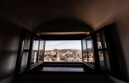 scenic view of latin cathedral and carmelite church through open window in lviv, ukraine
