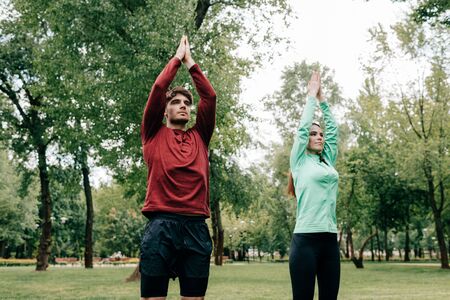 Young couple working out together on lawn in parkの写真素材
