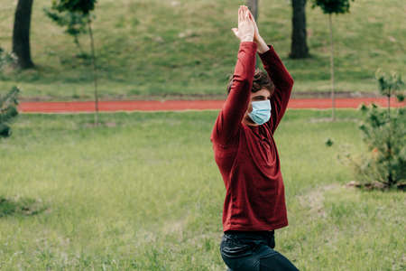Sportsman in medical mask exercising in parkの写真素材