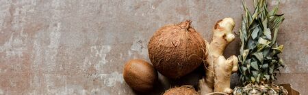 top view of tropical fresh fruits and ginger root on weathered surface, panoramic crop