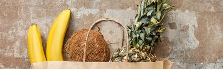 top view of tropical fresh fruits in paper bag on weathered surface, panoramic cropの写真素材